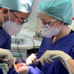 Bild zeigt zwei Ärzte die eine Zahnbehandlung durchführen Bild zeigt zwei Ärzte die eine Zahnbehandlung durchführen